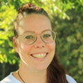 Portrait einer Frau mit einer Brille und braunen Haaren in einem Pferdeschwanz